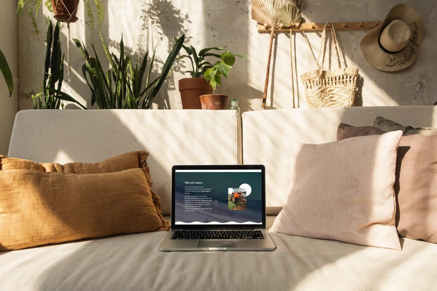 Laptop mit Blog Website auf Sofa mit Dekokissen