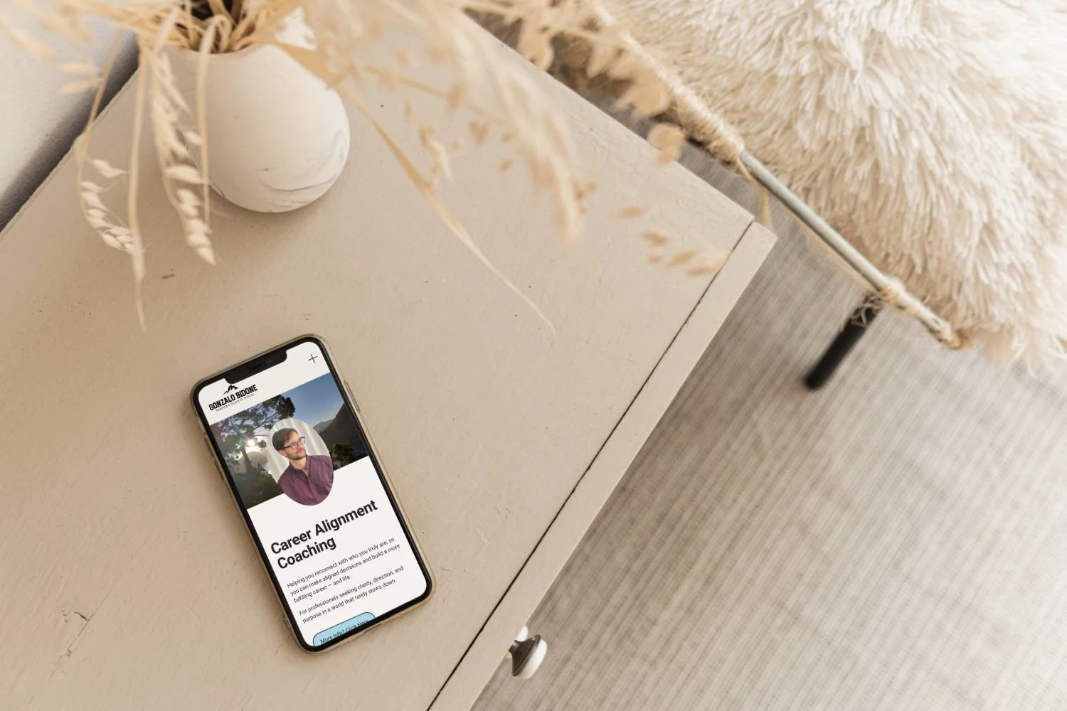 Handy mit Coach Website auf Beistelltisch