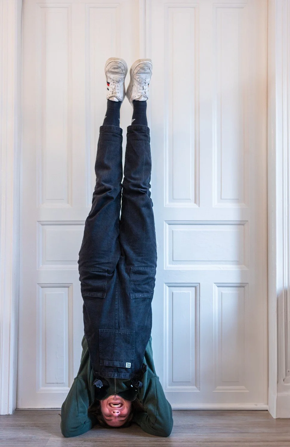 Franzi macht Kopfstand vor weißer Tür