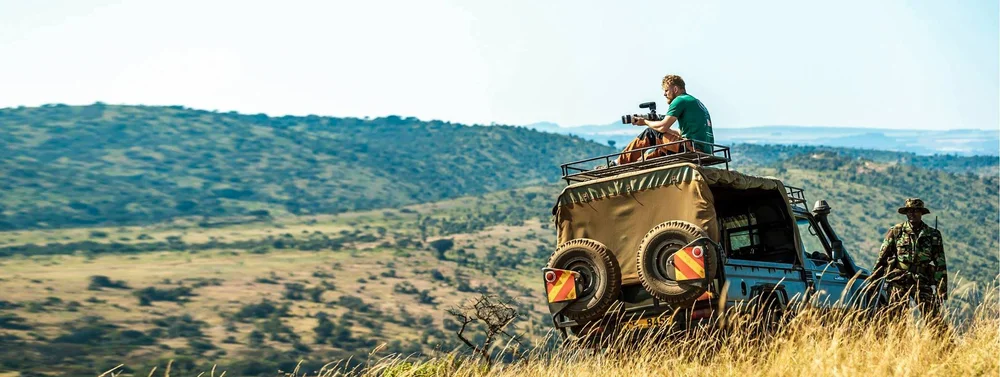 Ryan Lovejoy filming from a safari vehicle on location