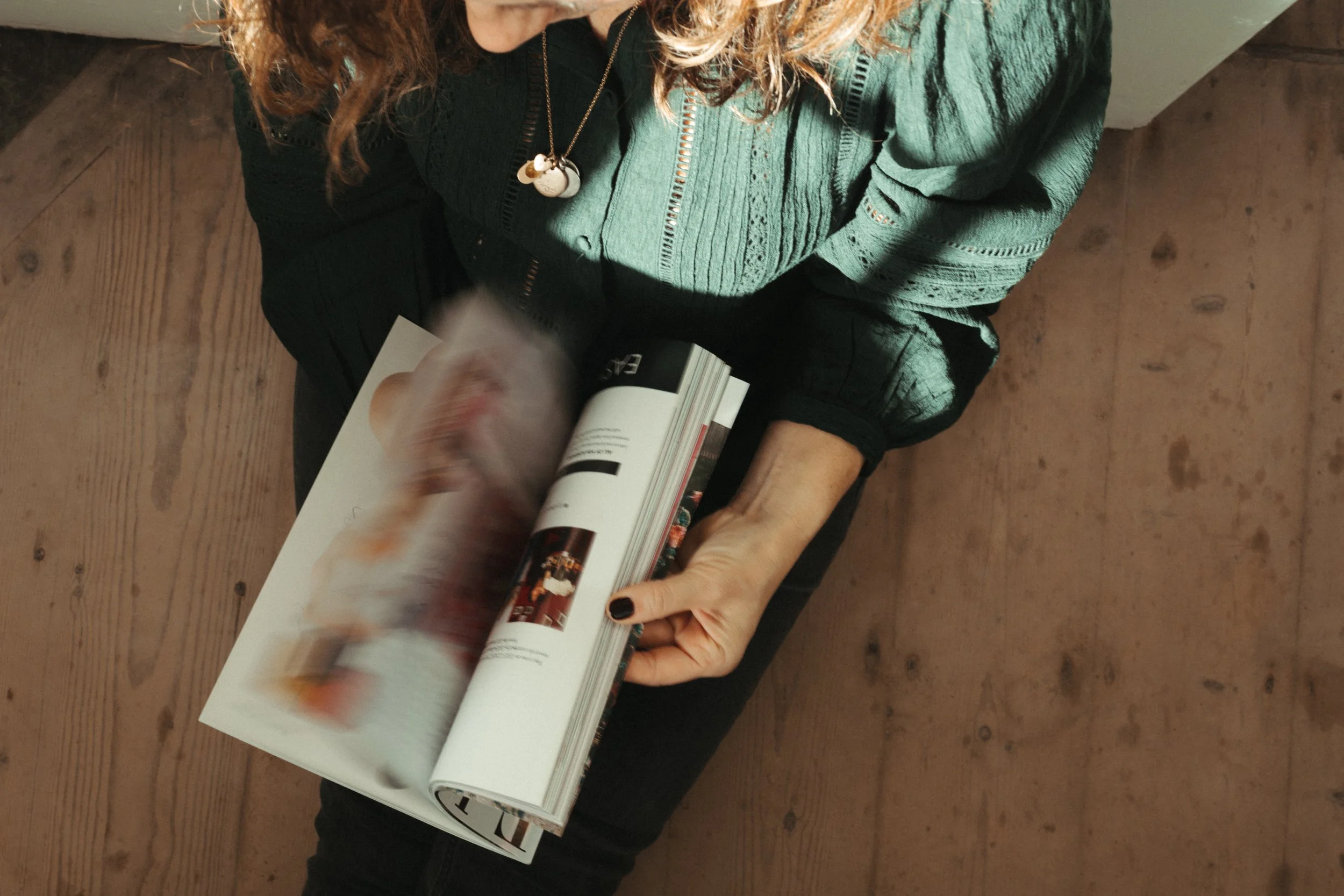 A person holding a stack of seven books with both hands. The person's face is slightly out of focus. The books are colorful and have titles related to writing, storytelling, and marketing.