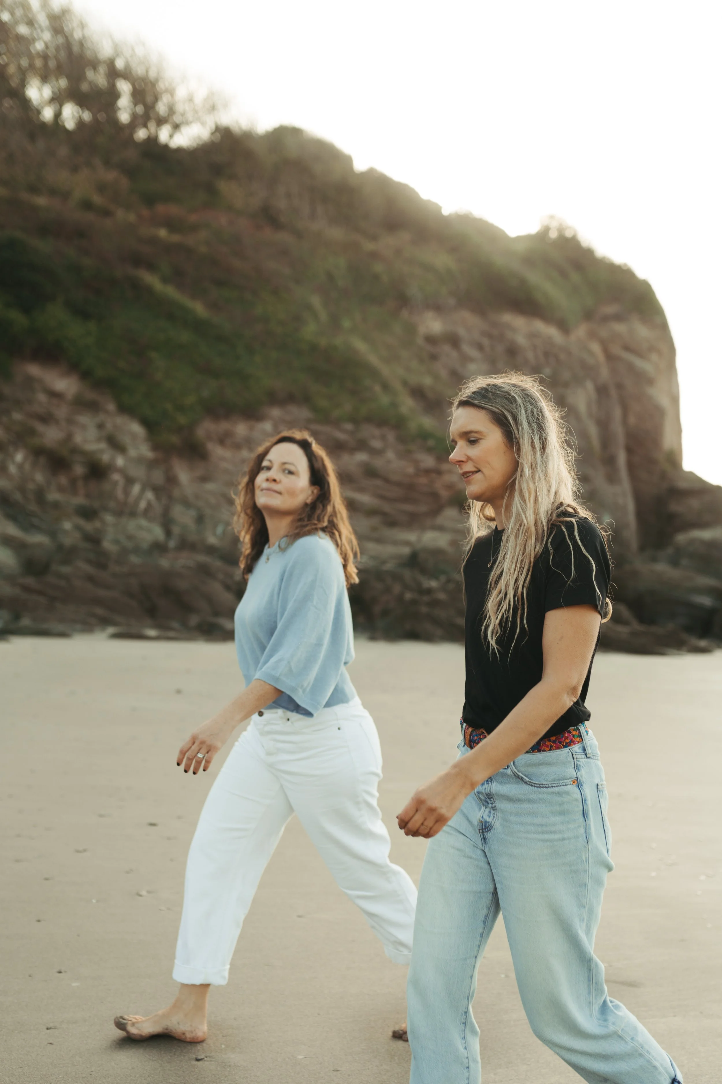 Photo shows Manfreda Cavazza and Felicity Haythorn, co-founders of storytelling agency Salt & Sage, walking on the beach in Devon