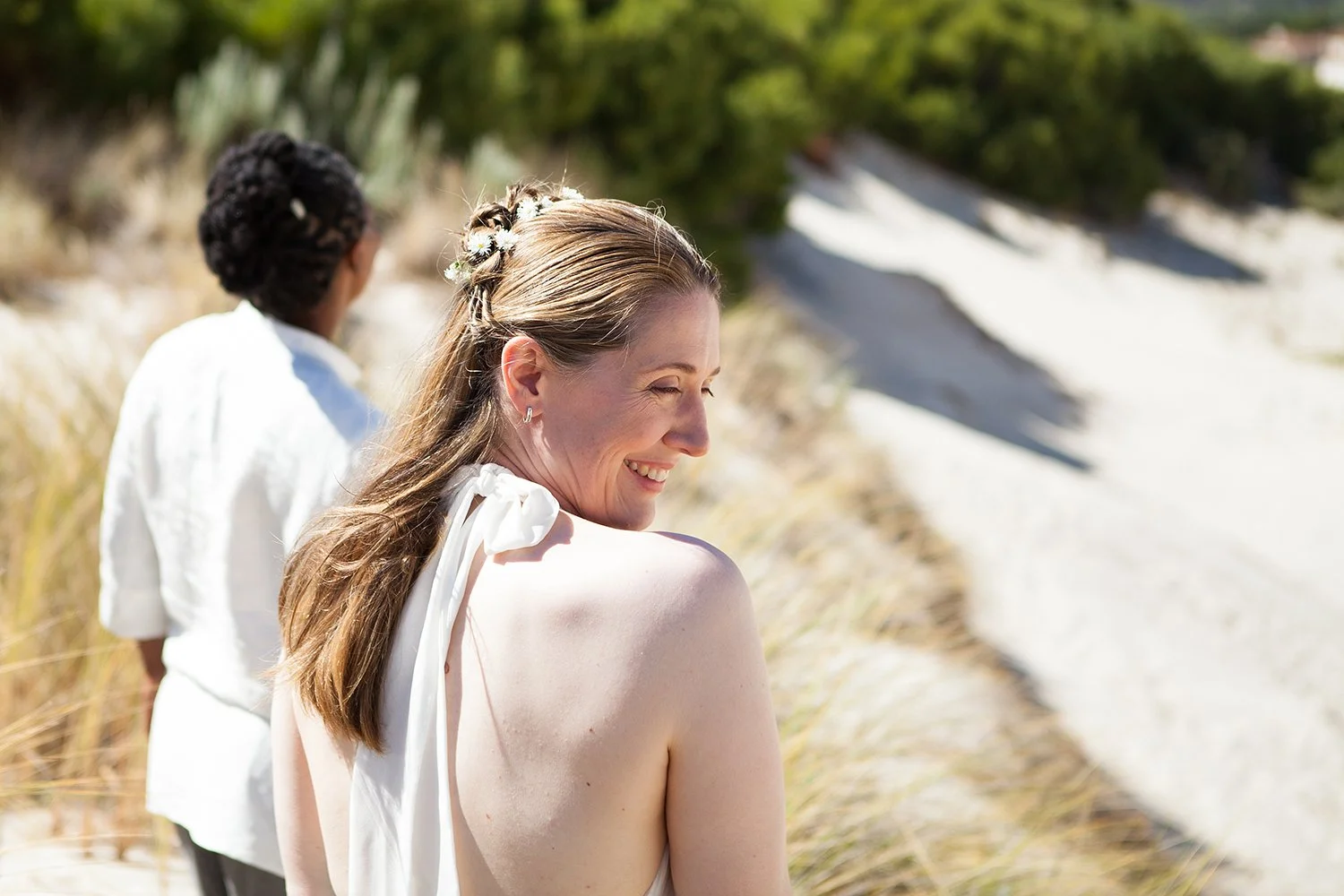 same sex bride looking over her shoulder in dunes