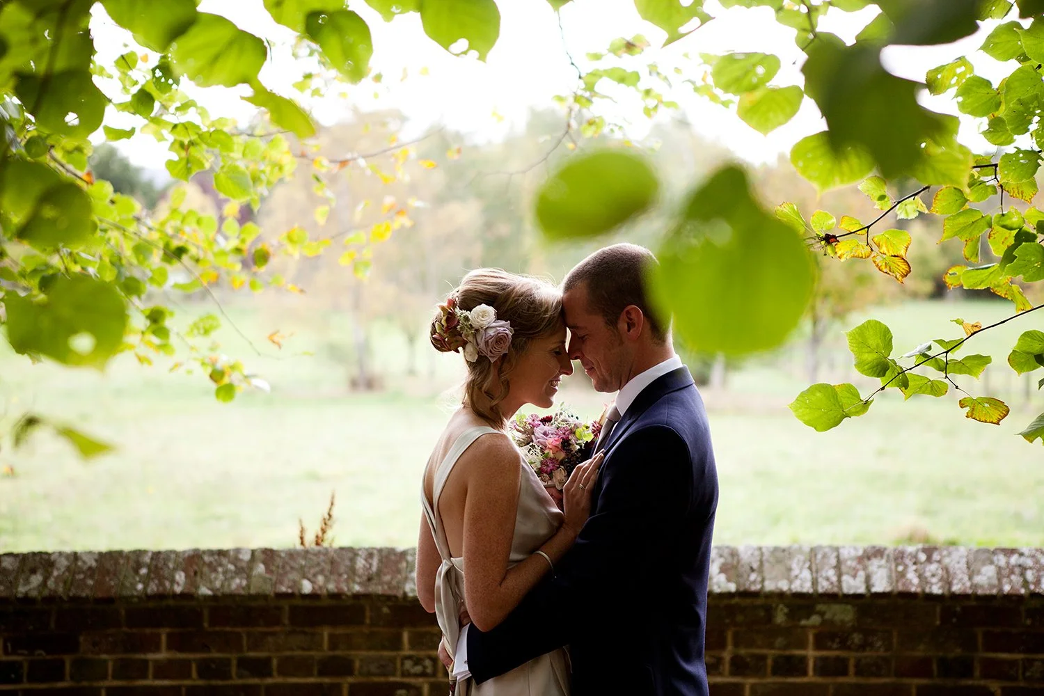 bride and groom hugging under tree