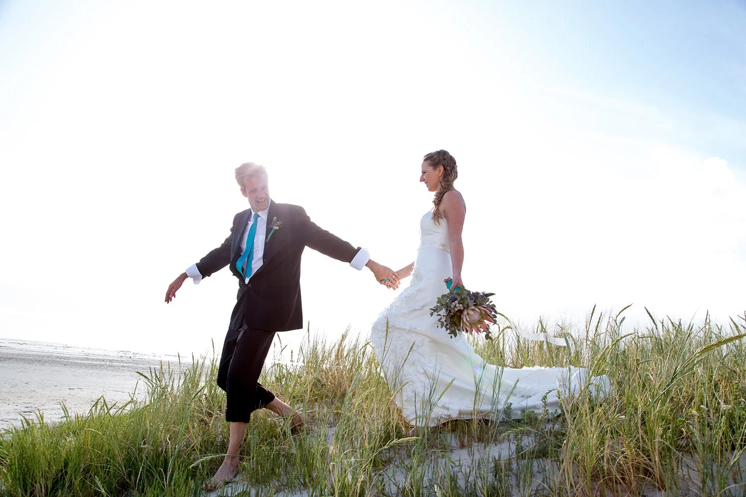 bride and groom holding hands walking in dunes in south africa