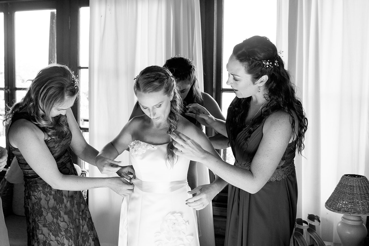 bride getting dressed with bridesmaids