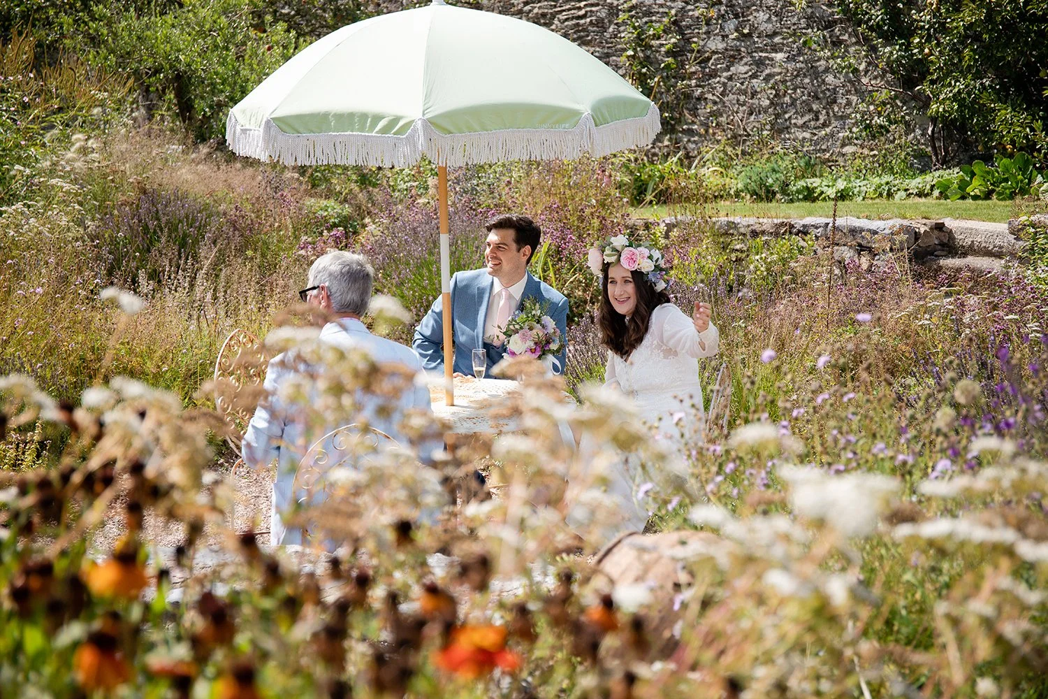bride and groom sitting at a table in garden setting