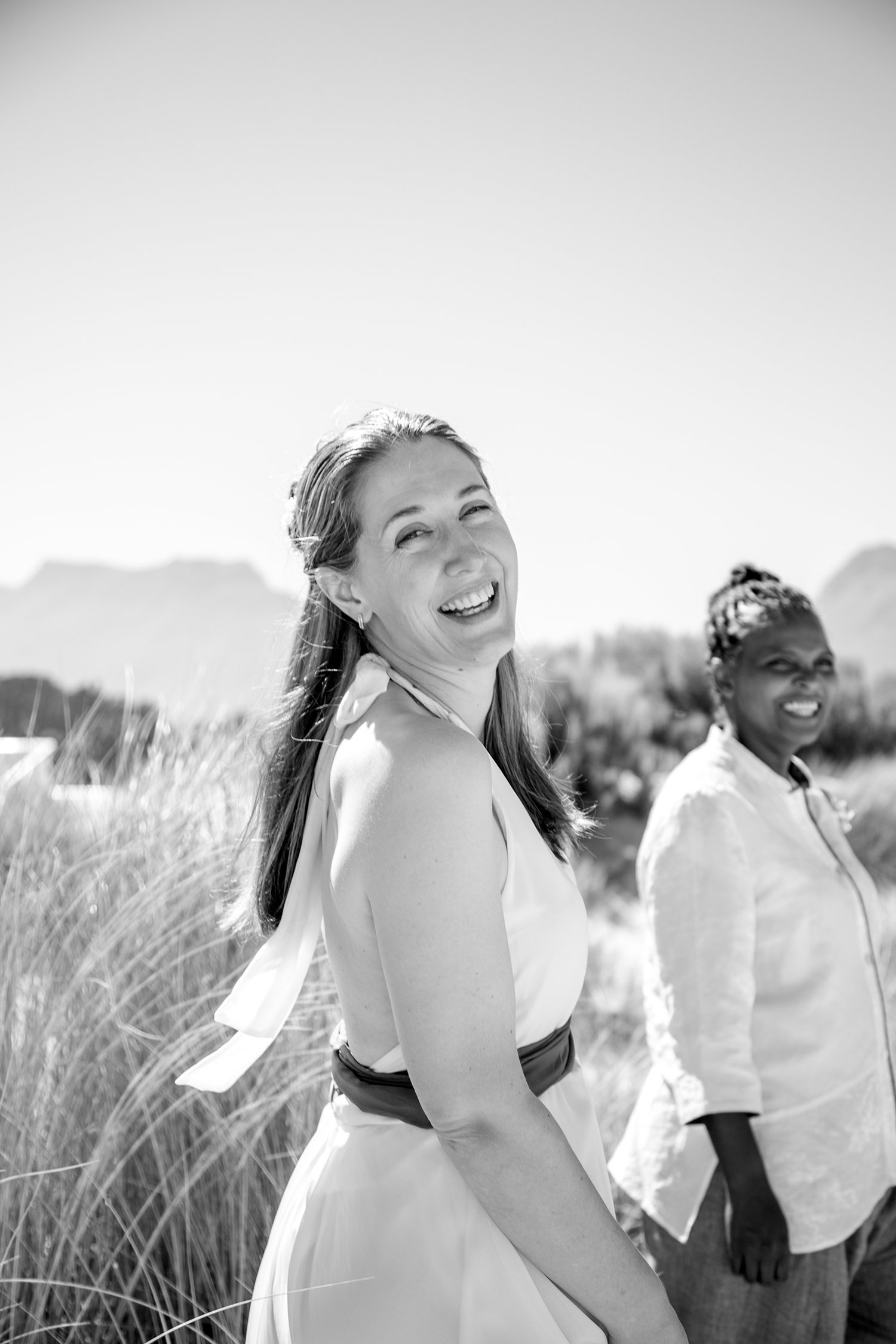 bride laughing into the camera on beach