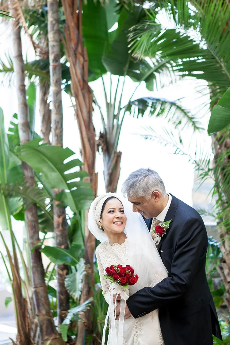 portrait of Indian bride and groom underneath palm trees