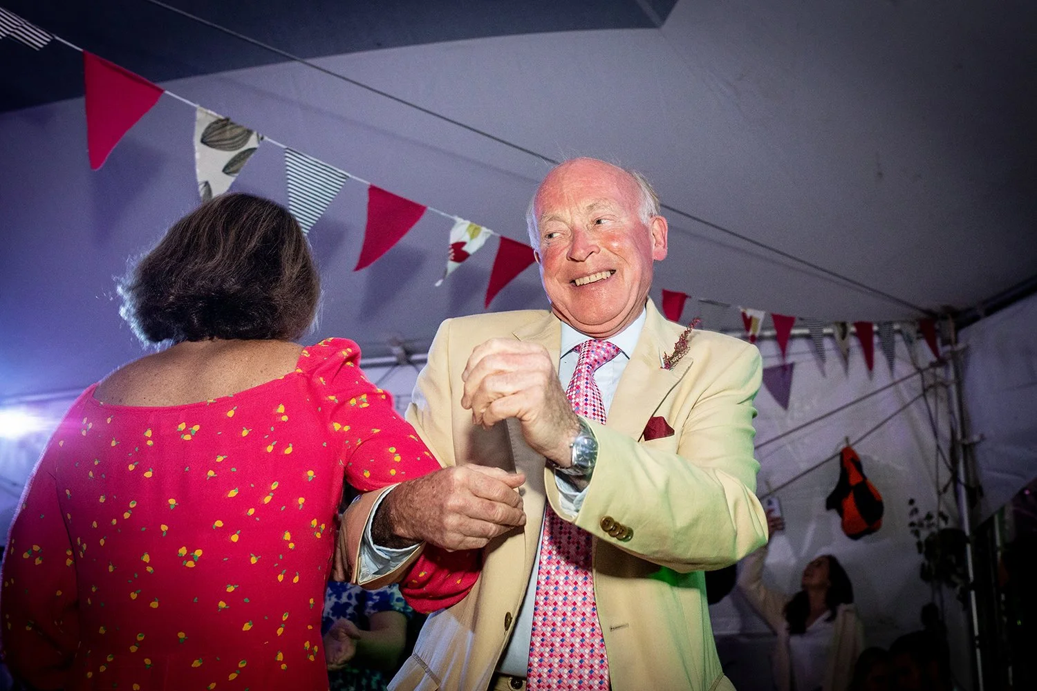 old man dancing at a wedding with a big smile on his face