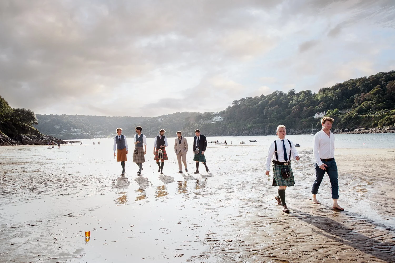 groomsman walking on beach at wedding in devon