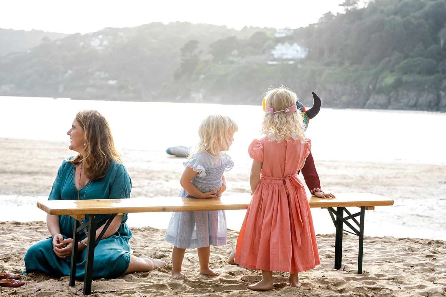 mom and her children sitting on beach at wedding in devon