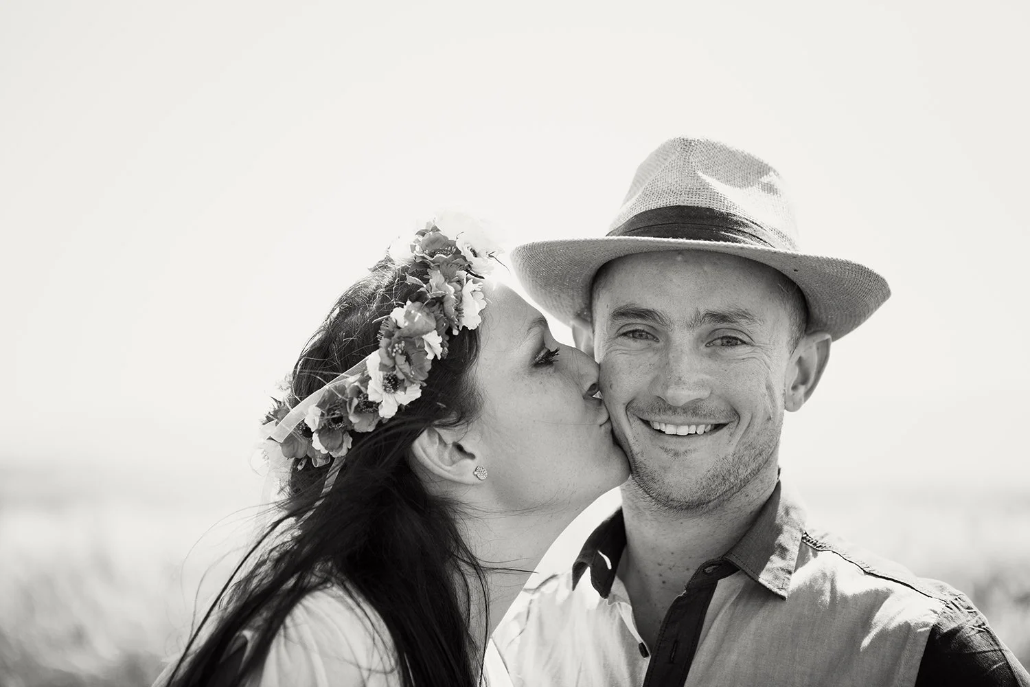 woman kissing man on cheek during couple shoot
