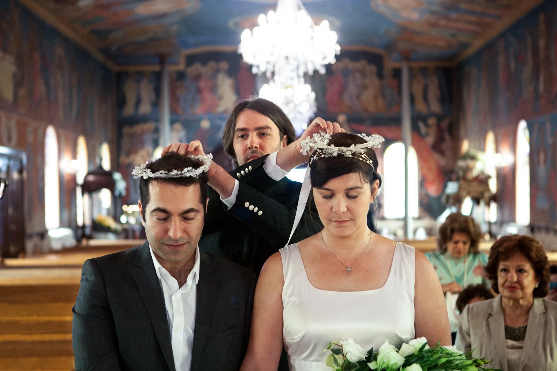 bride and groom with flower crowns during ceremony