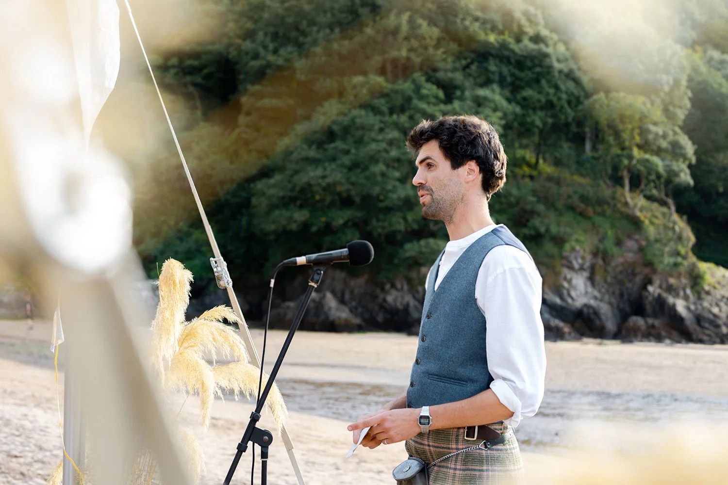groom giving a speech at beach wedding
