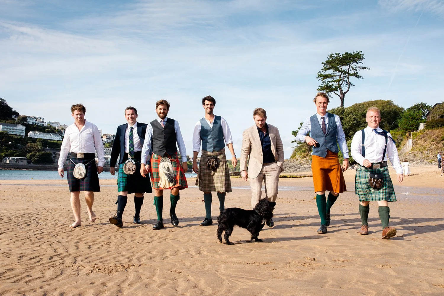 groomsman with quilts walking on beach in south devon