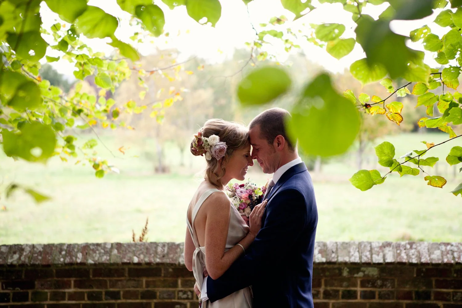 bride and groom hugging under trees