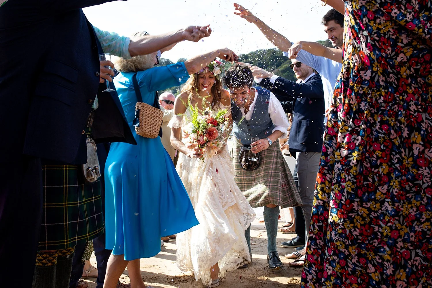 bride and groom with guests throwing confetti