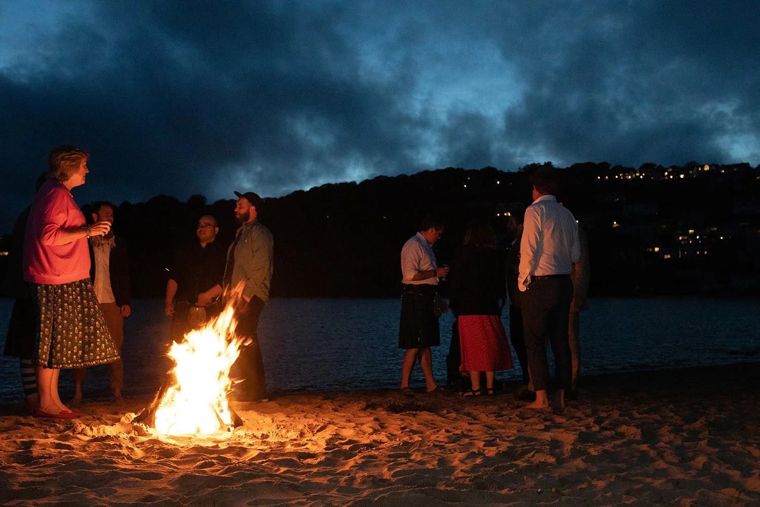 wedding guests around a fire on mill bay beach devon