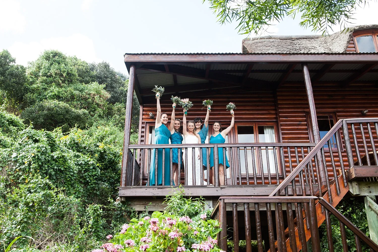 bride with her bridesmaids standing on balcony