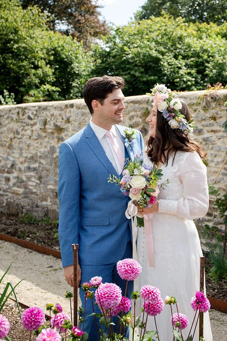 bride and groom looking at each other behind flowers