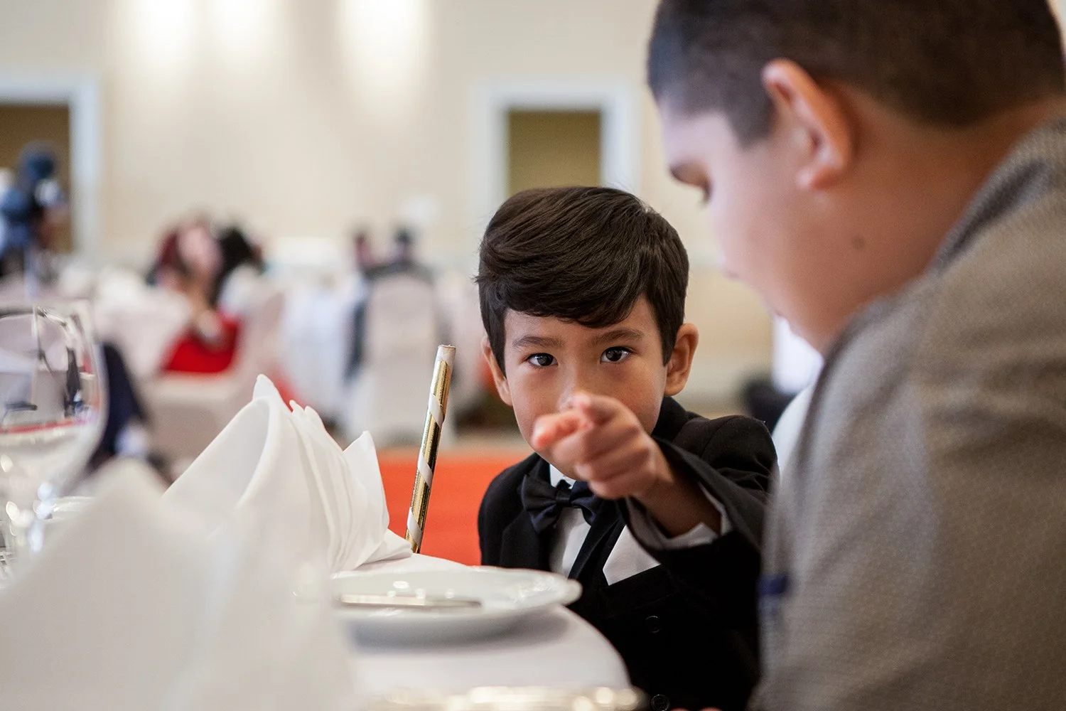 Hindu boy pointing straight at camera at indian wedding