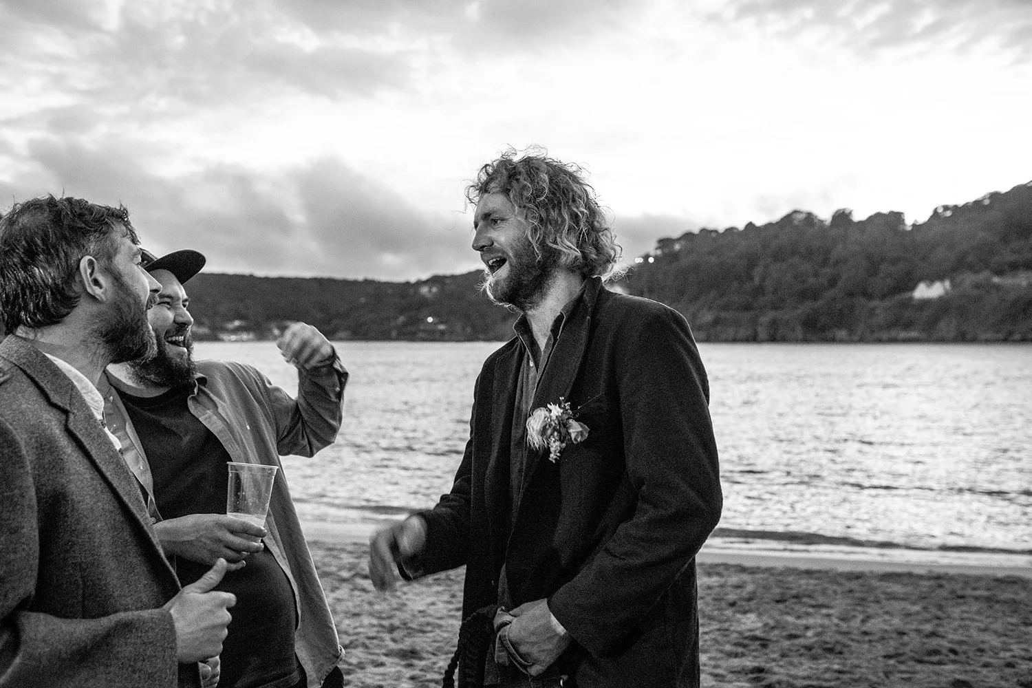 boys having banter at a wedding on beach