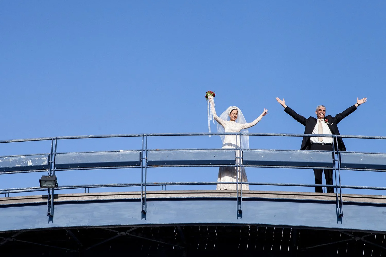 Hindu bride and groom standing on top of bridge
