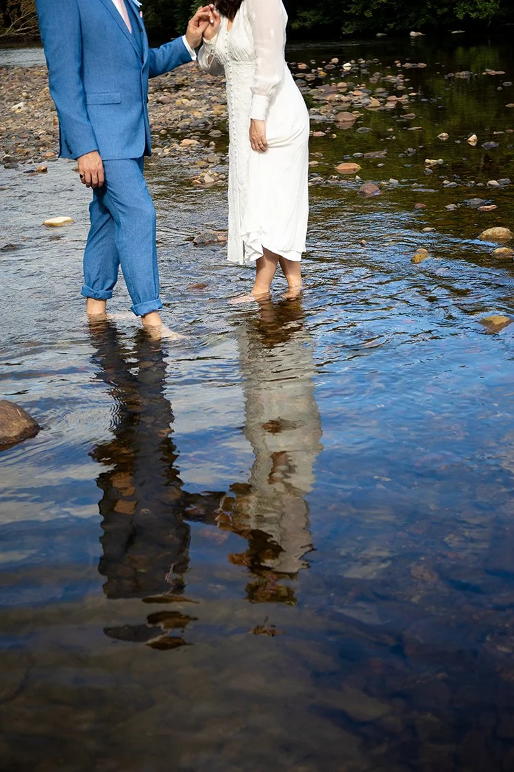 bride and groom with feet in water