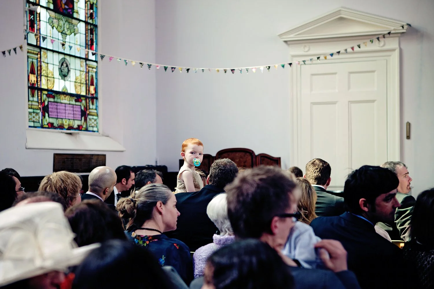 portrait of child amongst wedding guests