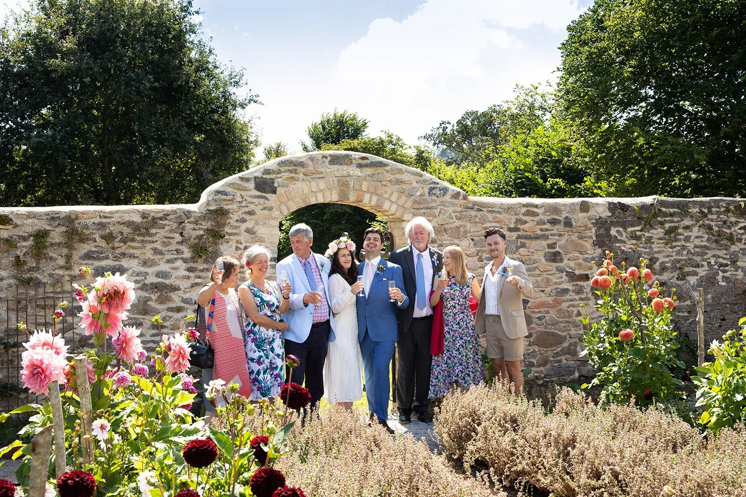 portrait of wedding family in front of wall in devon