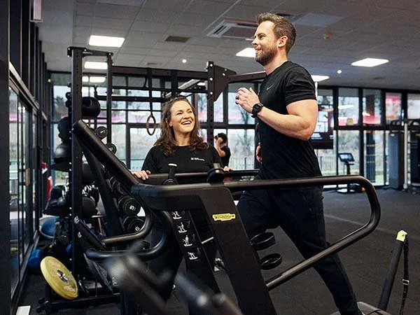 Tutor motivating a learner on an exercise bike during Level 3 PT training.