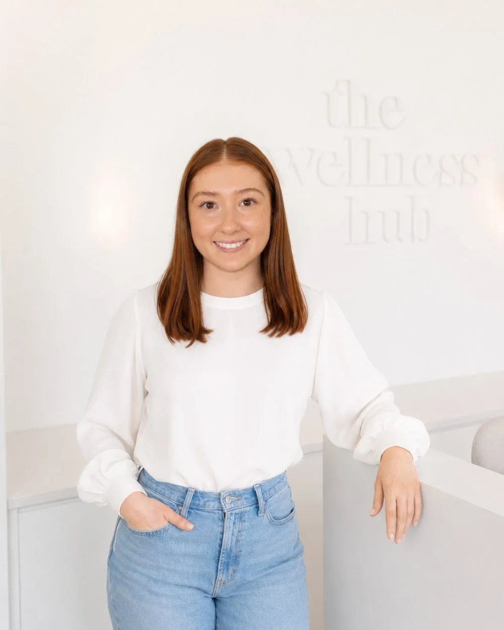 Dr. Brooke, chiropractor at The Wellness Hub in Stoney Creek, Ontario, smiling in the clinic reception