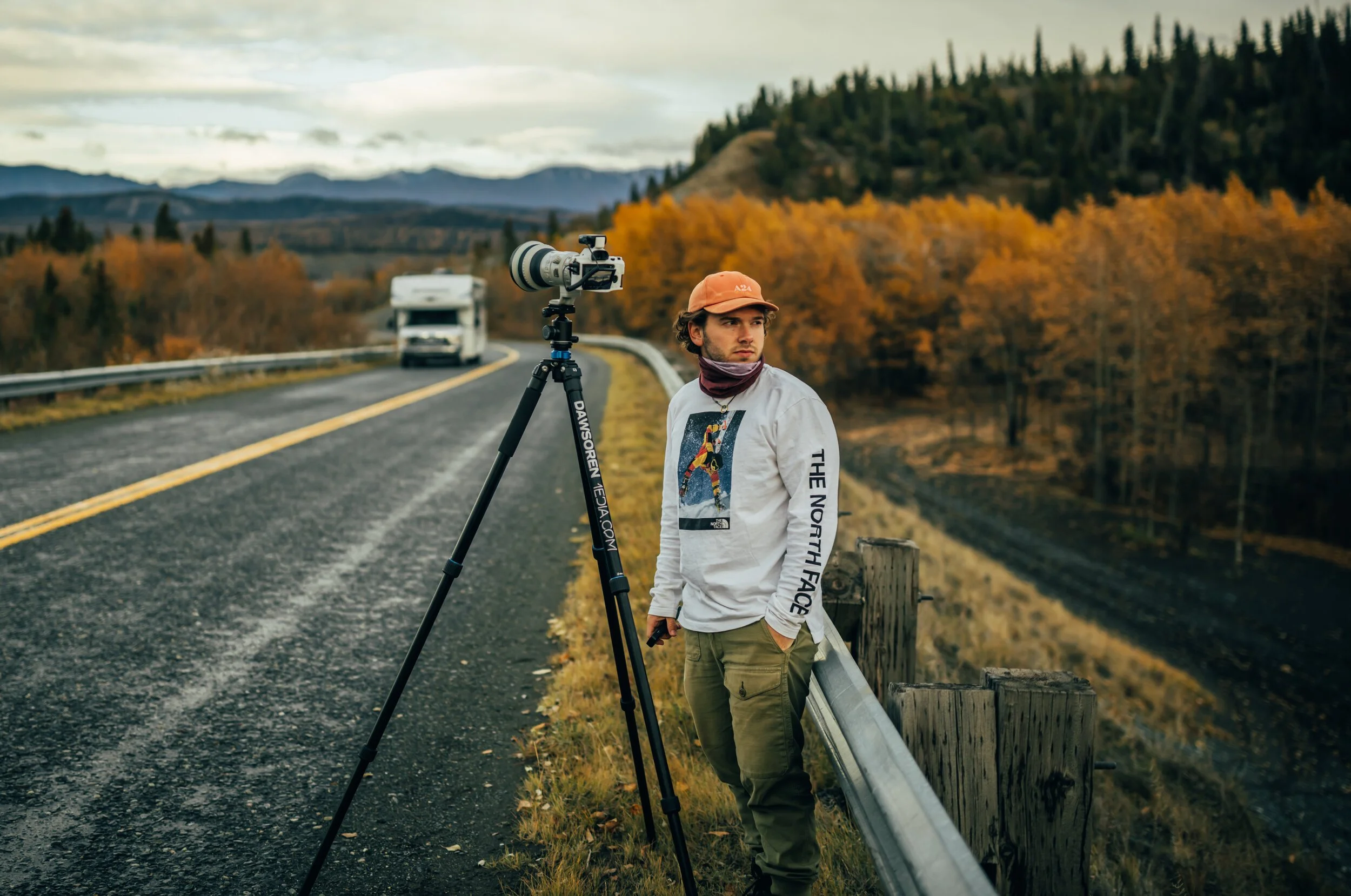 Photo of Nick Vigue of Navadise Media, Nick is standing near camera on tripod with rv in background and fall foliage