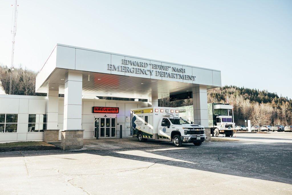 Emergency Department entrance labeled "Edward 'Eddie' Nash Emergency Department" with an ambulance and ambulance truck parked outside.