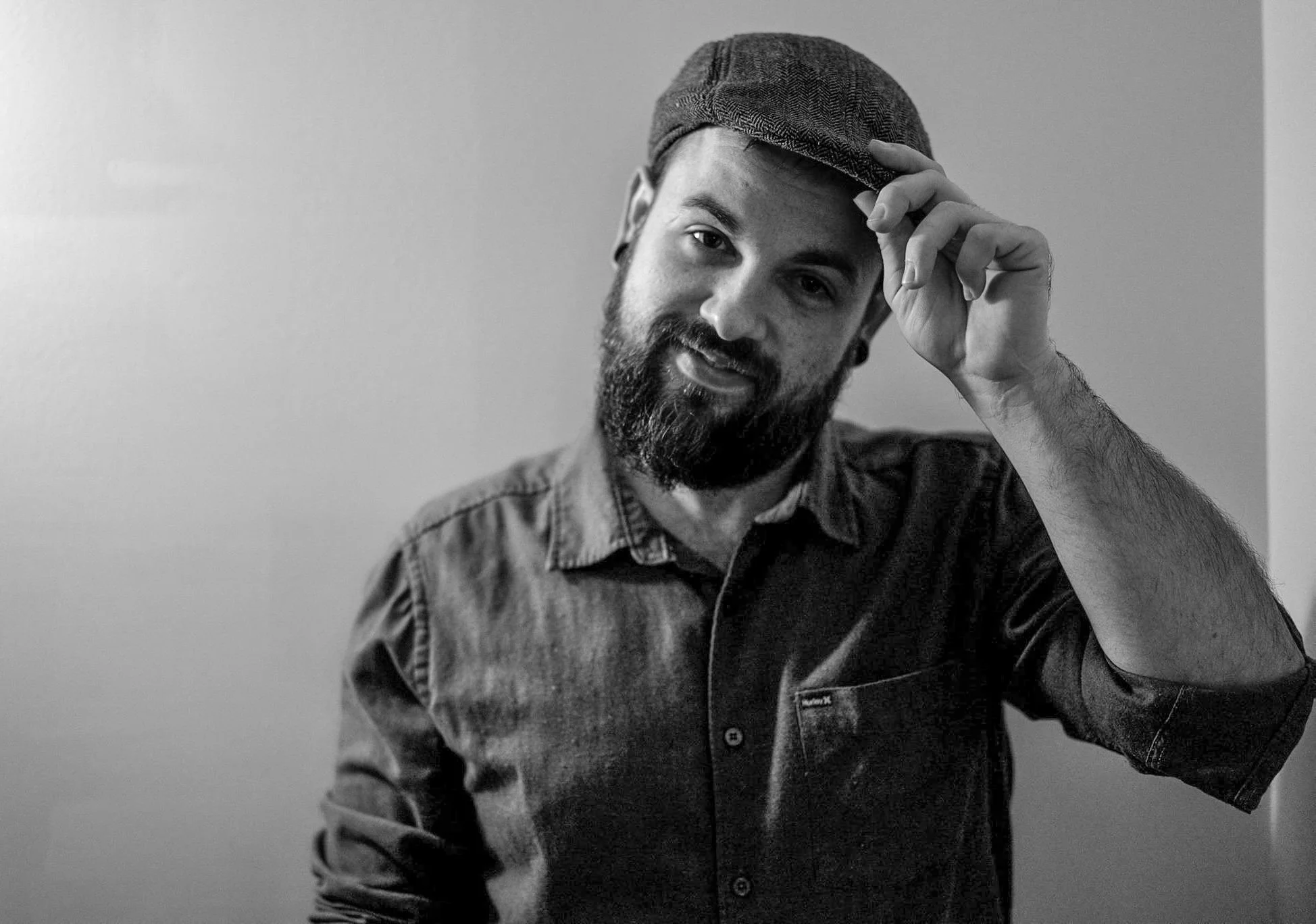 Ryan Nava tipping his hat in studio shot