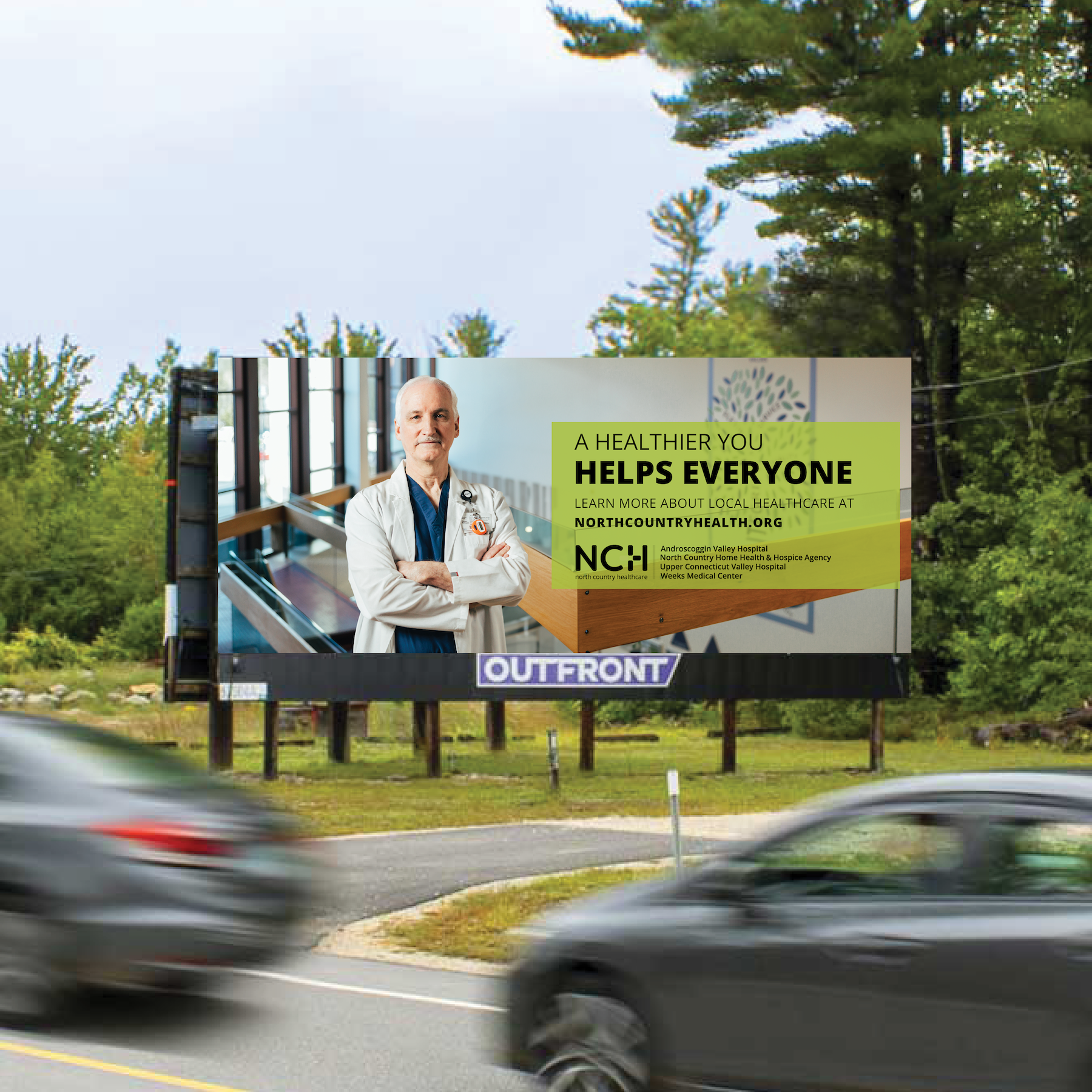 Billboard design with two cars zooming by and Billboard for NCH in background featuring doctor and text: "A Healthier You Helps Everyone"...
