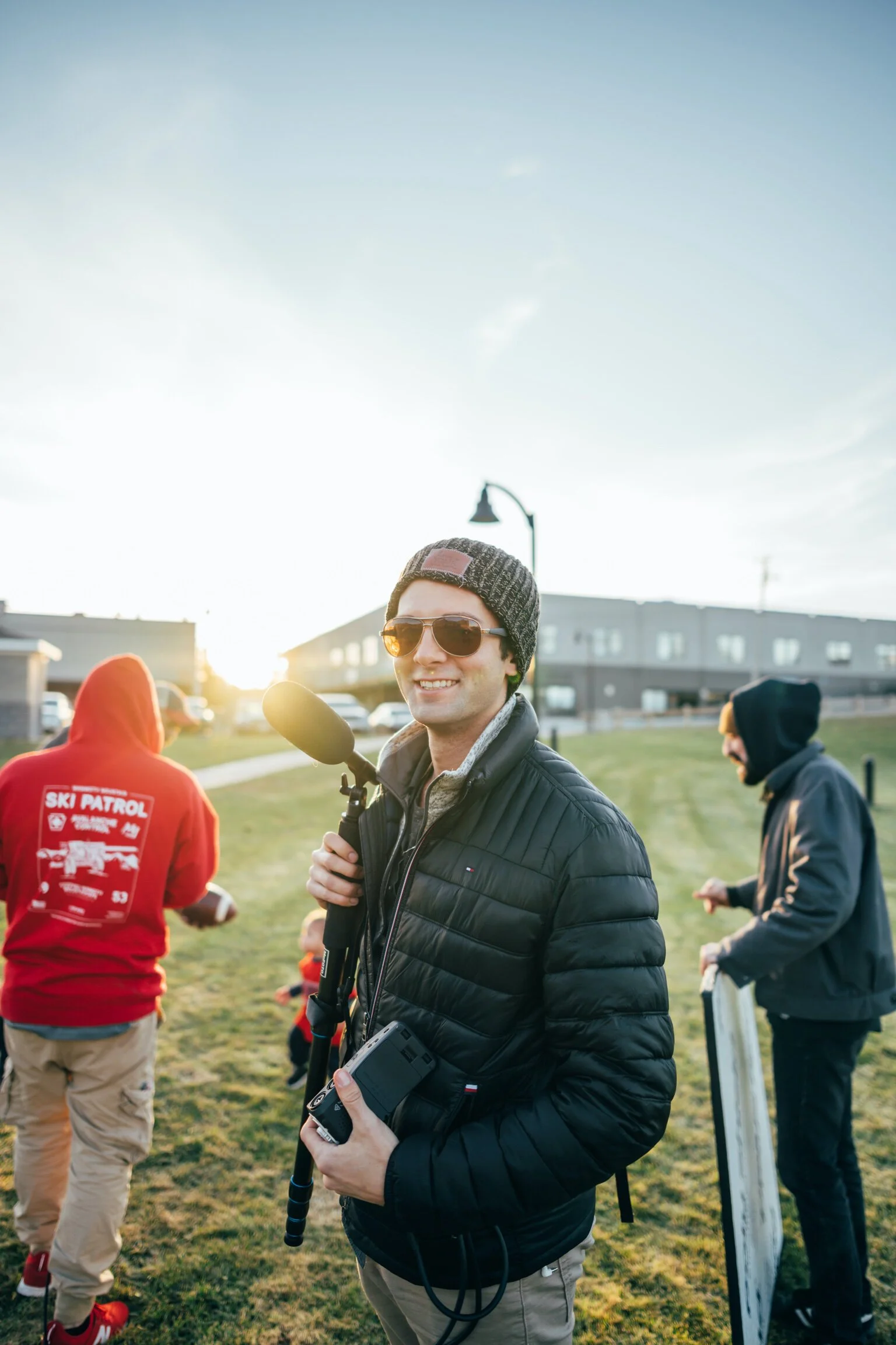 Lucas Roy holding recording equipment with other team members in background