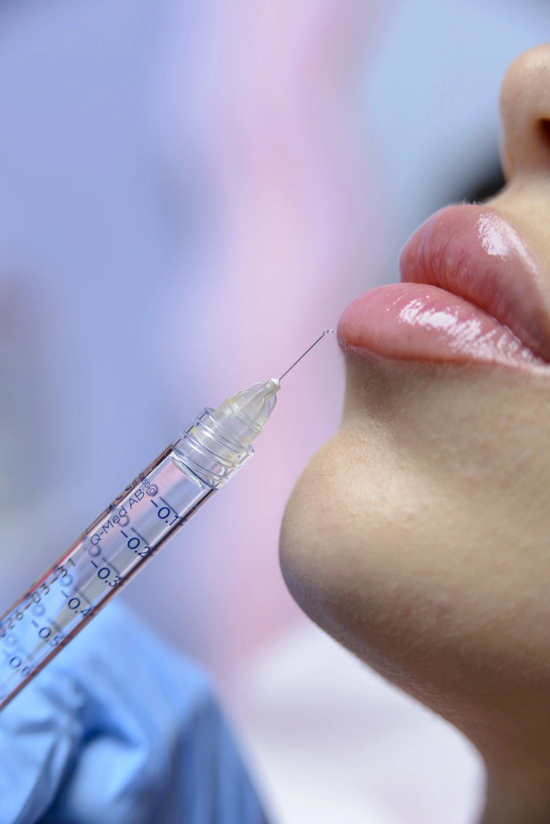 Une personne reçoit une injection à la lèvre supérieure, avec un médecin ou un professionnel de la santé en blouse bleue.