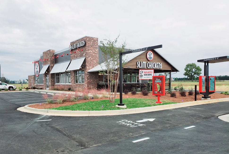 Exterior of Slim Chickens fast-food restaurant with a drive-thru and parking lot.