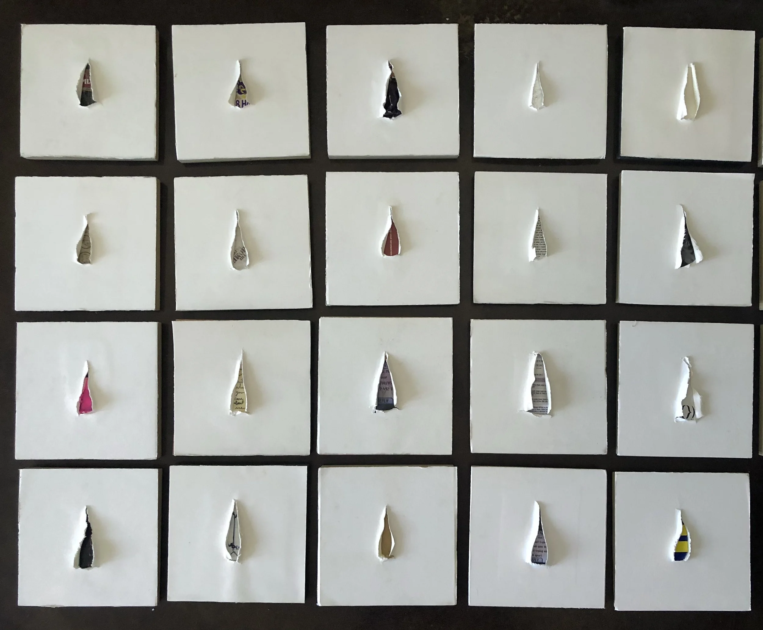 20 small square white cards arranged in a 4x5 grid, each with a tear in the center revealing torn pieces of colorful paper behind.
