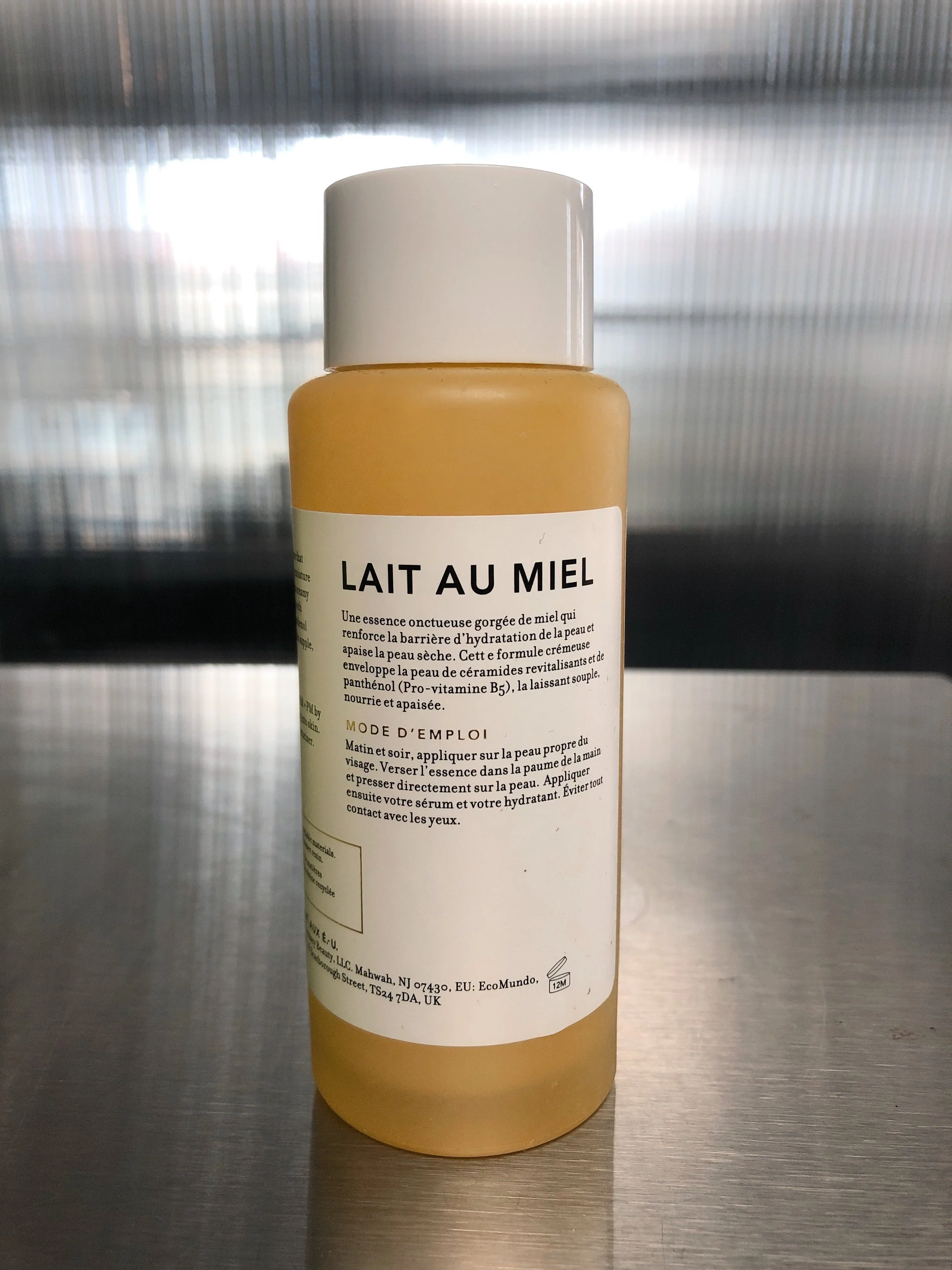Back of Farmacy Honey Milk Toner bottle on a metal surface