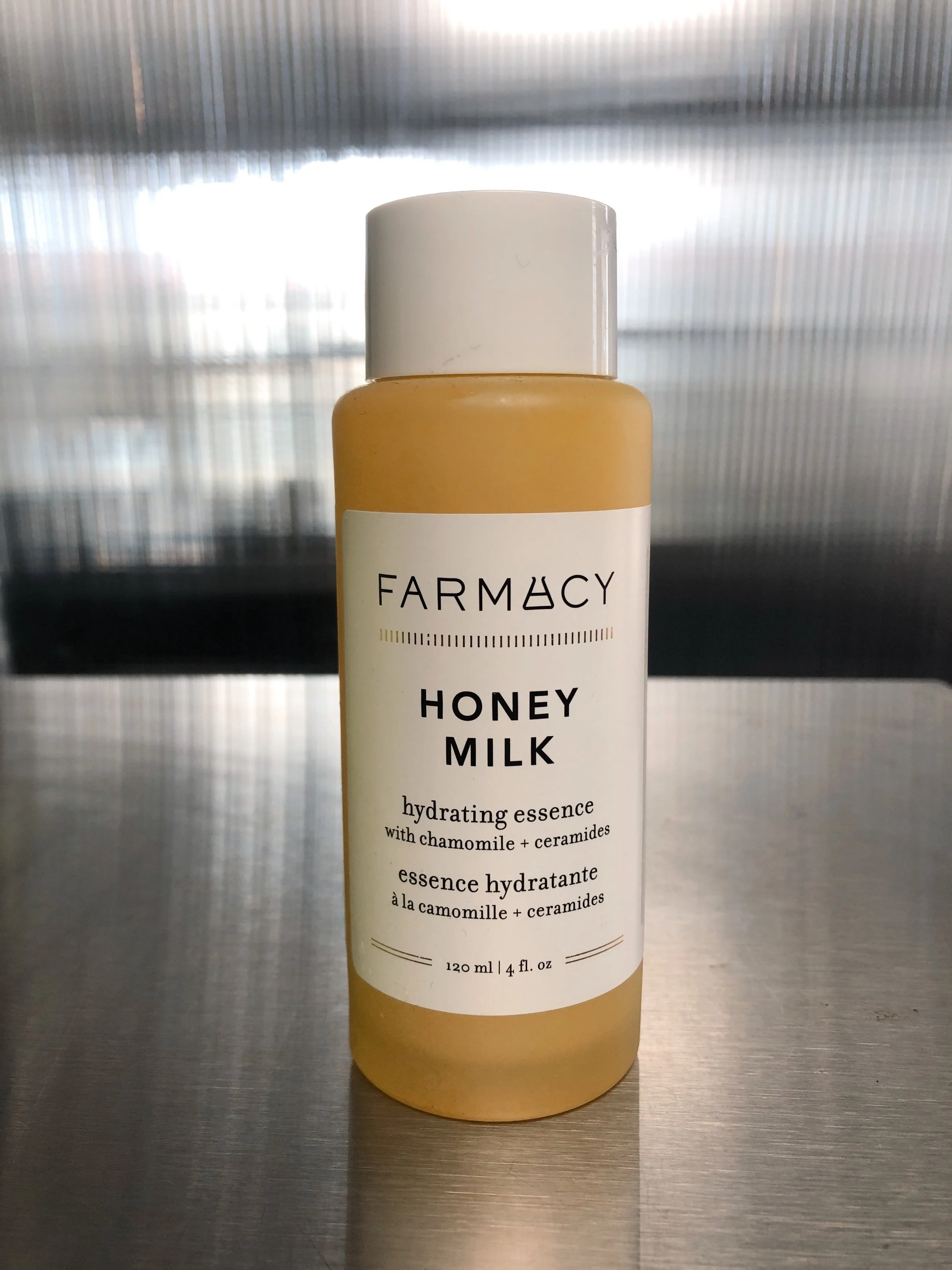 Front of Farmacy Honey Milk Toner bottle on a metal surface