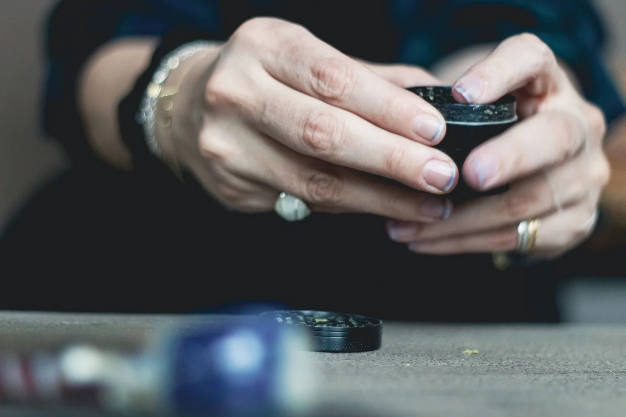 Hands holding cannabis grinder