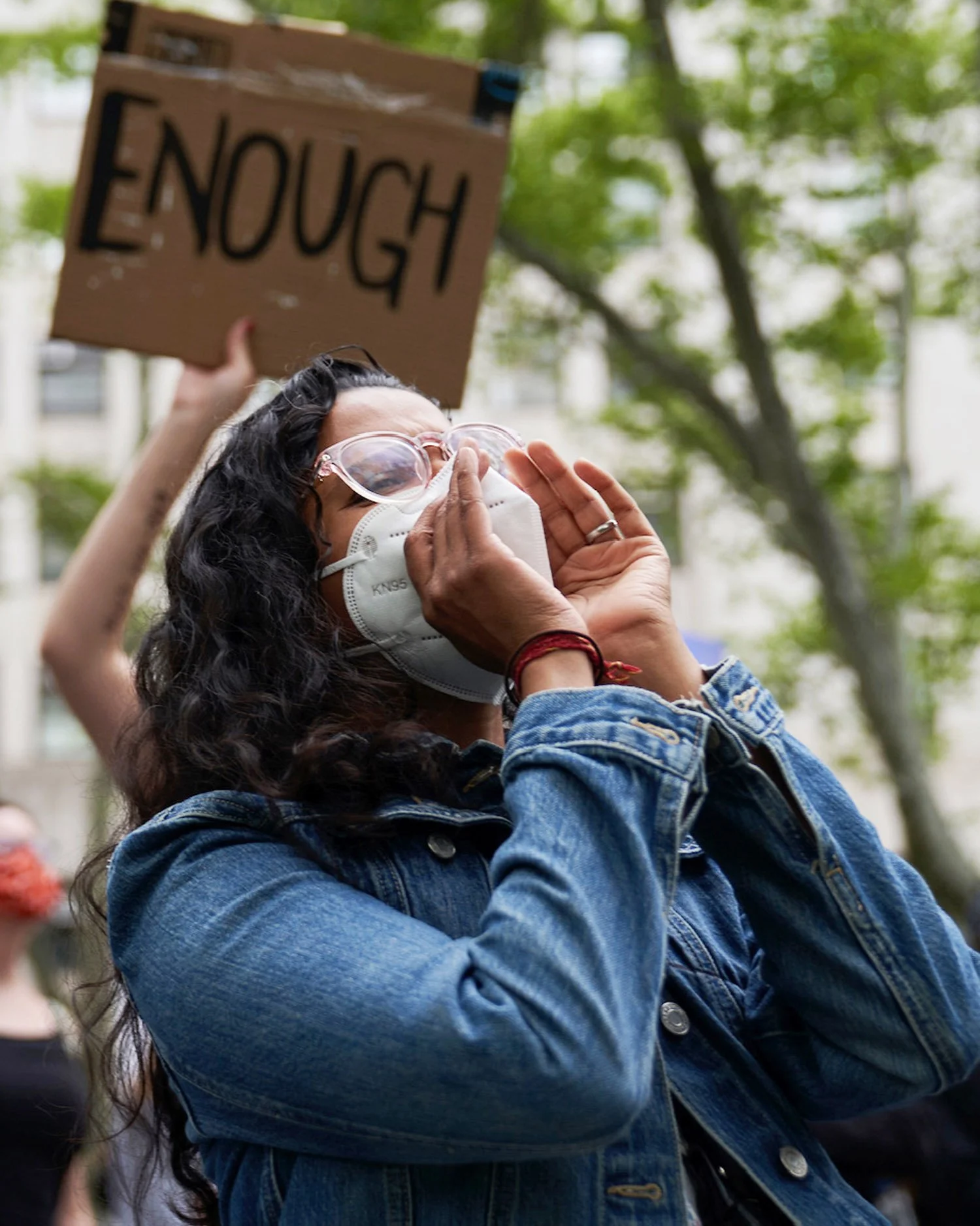 woman-activist-shouting-with-enough-sign-behind-her