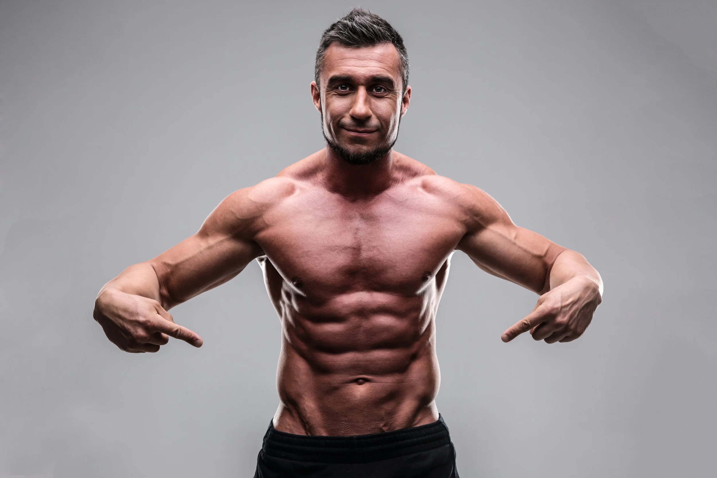handsome-muscular-man-pointing-at-his-abs-over-gray-background_SKZOxgABi.JPG