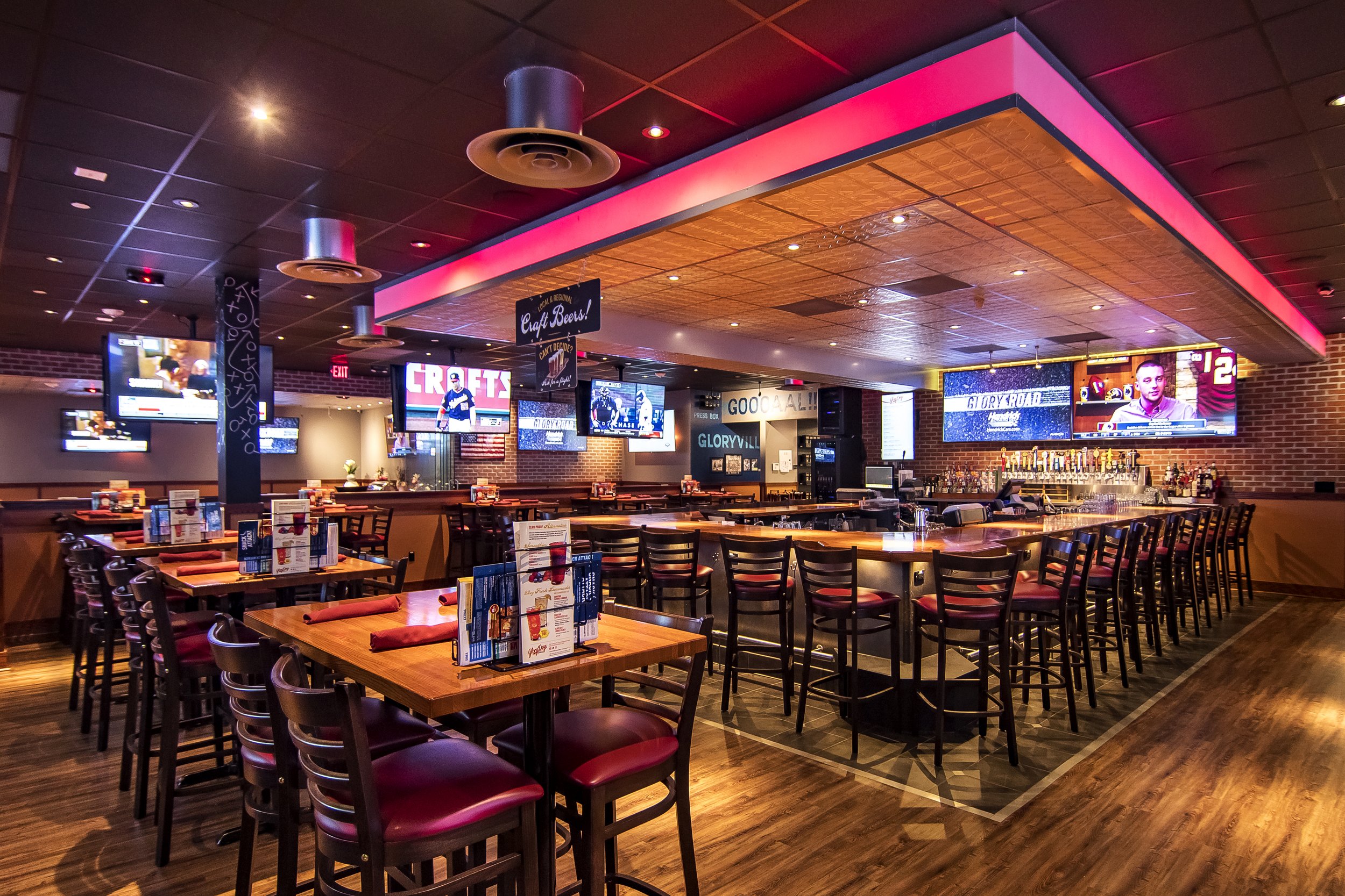 Neon Pink Sports Bar with Bar Stools and High Top Tables 
