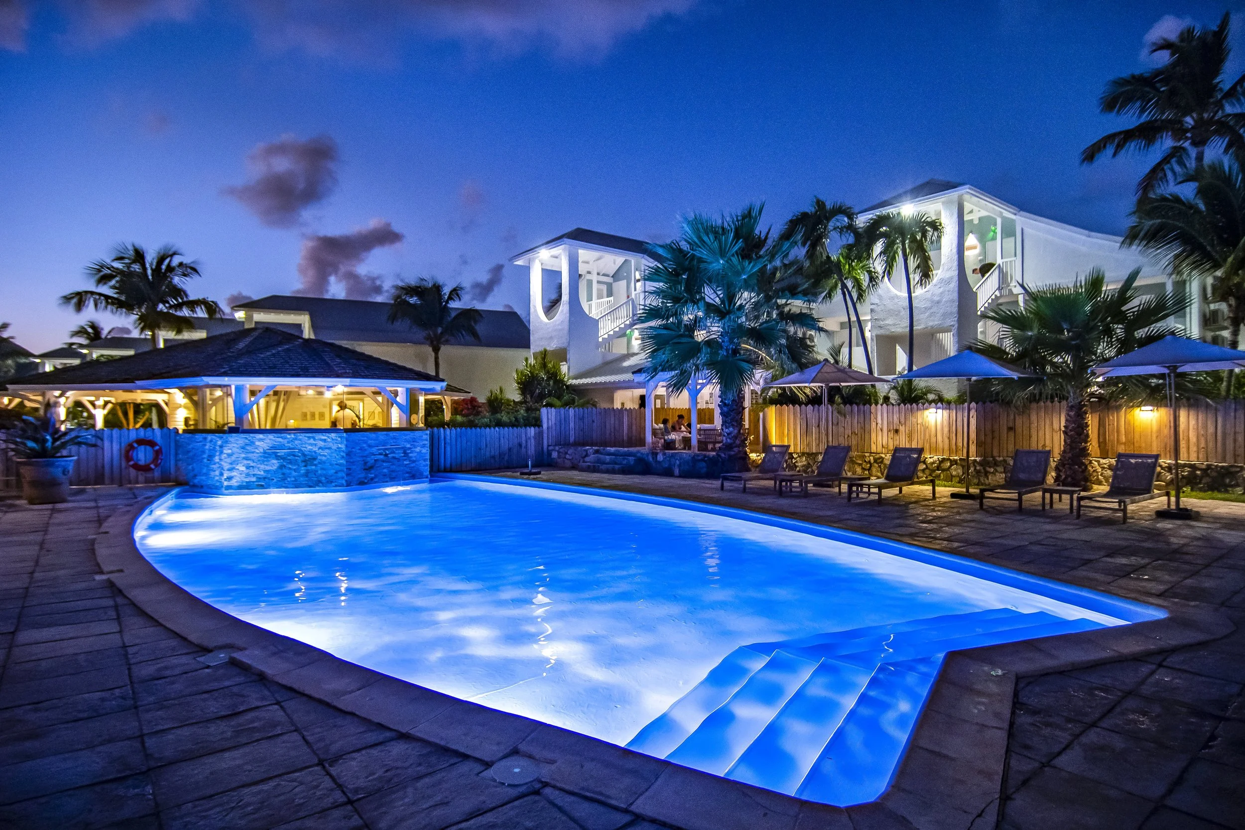 luxury home with blue pool lights somewhere tropical  