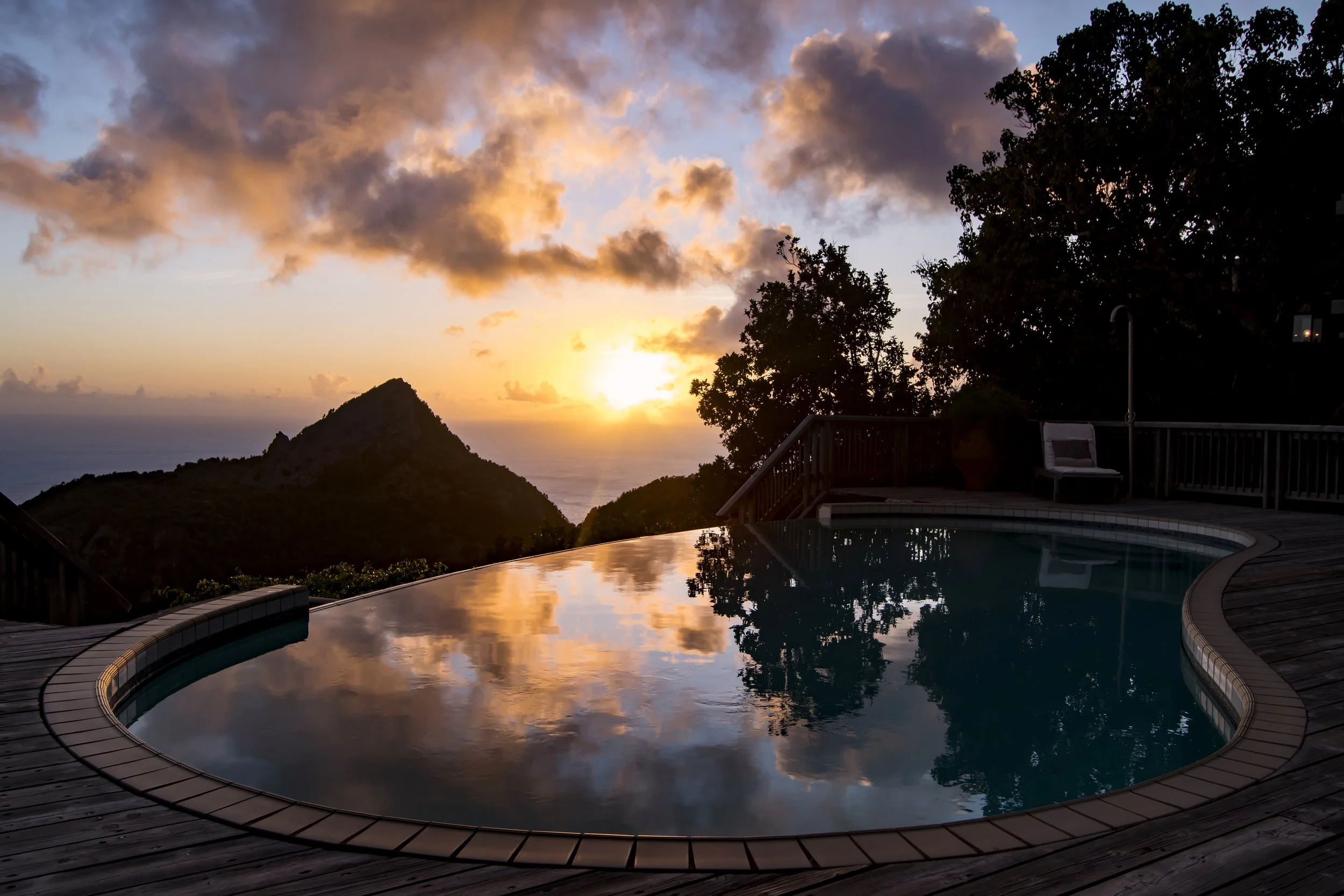 Tropical Home Infinity Pool over looking the mountains at Sunset 
