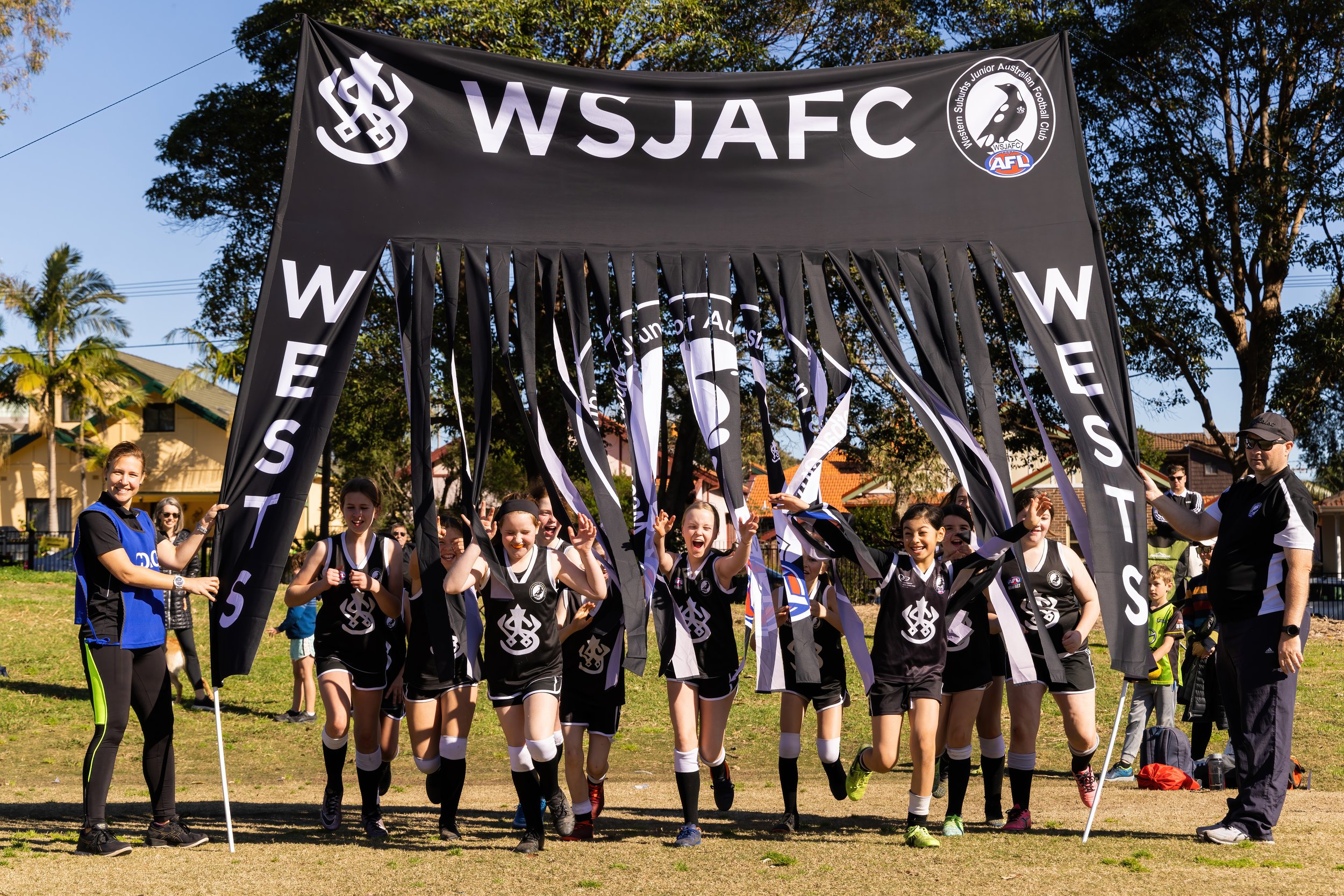 WSJAFC-banner-girls-team-arriving-field.jpg